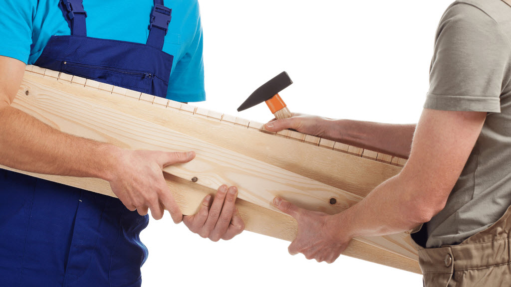 composite timber decking professionals holding hammer and timber